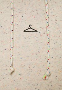 Sudadera con capucha beige claro con motas coloridas, con un logo de perchero negro y cordones trenzados con acentos coloridos. Textura suave.