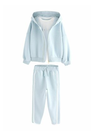Ensemble de survêtement bleu clair composé d'une veste à zip et d'un pantalon de jogging assorti avec des rayures blanches sur les côtés. Fabriqué en tissu doux avec des poignets élastiques.