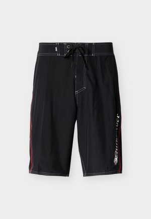 Schwarze knielange Badeshorts mit weißen Nähten, Schnürbund, roten Seitenstreifen und weißem Schriftzug am rechten Bein.