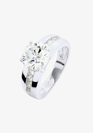 Bague en argent avec une grande pierre ronde claire au centre et de plus petites accents clairs le long de la bande. Surface lisse et polie.