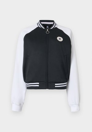 Czarna i biała kurtka varsity zapinana na zamek, z prążkowanym kołnierzem i ściągaczem, przednimi kieszeniami oraz okrągłym logo Converse All Star na piersi.