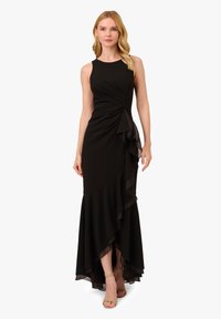 Abito nero con corpino aderente, volant asimmetrici a strati all'orlo e un design alto-basso. Tessuto liscio ed elasticizzato con una silhouette strutturata.