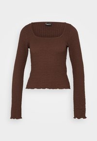 Brun långärmad topp med fyrkantig halsringning, texturerad tyg, figurnära passform och scallopad nederkant, designad för att sitta tajt.