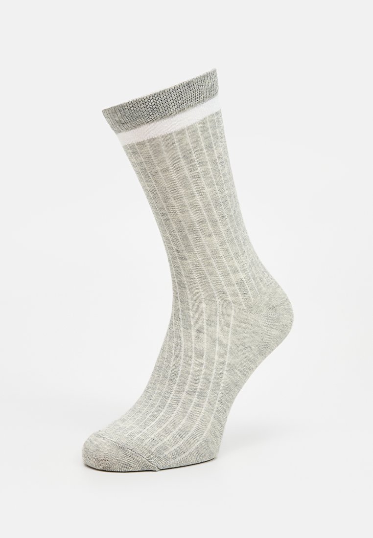 Calcetines de rayas grises con una banda blanca en la parte superior, fabricados con un tejido suave y texturizado, diseñados para un ajuste cómodo.
