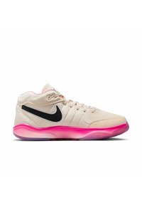 Baskets basses Nike beige clair avec un swoosh noir, une doublure intérieure rose et une semelle translucide rose vif, vues de côté.