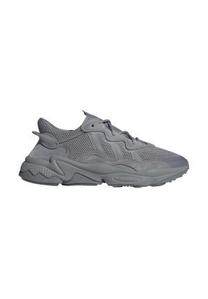 Baskets de sport grises avec dessus en mesh et daim, semelle épaisse et fermeture à lacets, vues du côté extérieur sur fond blanc.