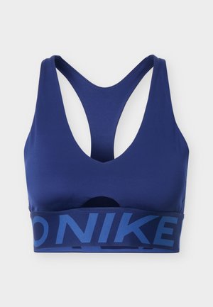 Niebieski sportowy stanik Nike z tyłem typu racerback i szeroką elastyczną taśmą z logo Nike w ciemniejszym odcieniu niebieskiego.