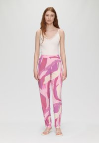 Pantalons à motifs roses avec différentes nuances de rose et de crème. Tissu léger, coupe décontractée et une taille embellie de dentelle subtile.