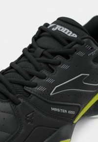 Melna sporta kurpe ar teksturētu virsmu, ar šņorēm, logo un spilgti dzeltenu akcentu uz zoles. Modelis: Master 1000.