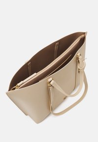 Bežová kožená kabelka s dvoma priehradkami, z toho jedna na zips. Hladký povrch, pevné uši a zlaté kovové doplnky.