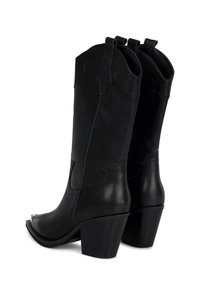 Botas de cowboy de cuero negro con una punta ligeramente afilada, tacón apilado y costuras decorativas en el eje. Textura suave.