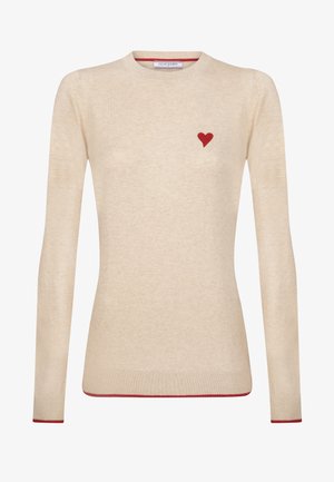 Beige gebreide trui met een rode hartversiering op de linkerborst en rode accenten langs de manchetten en de zoom. Ronde halslijn.
