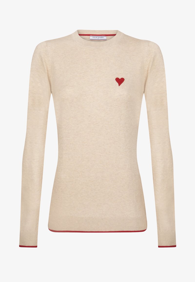 Beige gestrickter Pullover mit einer roten Herzverzierung auf der linken Brust und roten Akzenten an den Bündchen und dem Saum. Runder Ausschnitt.