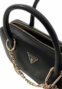 Zwarte leren handtas met dubbele bovenhandvatten, gouden kettingaccenten en een ritssluiting. Voorzien van een gouden logo-plaatje en een gestructureerd oppervlak.