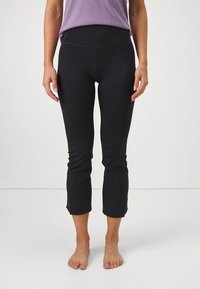 Črne kratke legice iz mehke, raztegljive tkanine z visokim pasom. Gladek otip, oprijet dizajn brez vidnih kovinskih dodatkov.