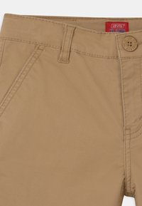 Khaki kraťasy Levi's XX Chino s hladkým bavlněným materiálem, pasem s poutky na opasek, zapínáním na knoflík a předními kapsami s plochým střihem.