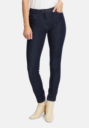 Jeans skinny blu scuro con vita media, dotati di chiusura a pulsante, tasche anteriori e posteriori e dettagli di cucitura a contrasto.