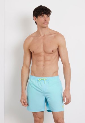 Pantaloni da bagno azzurri chiari realizzati in tessuto ad asciugatura rapida, con vita elastica munita di un laccio regolabile giallo neon e un piccolo dettaglio del logo.