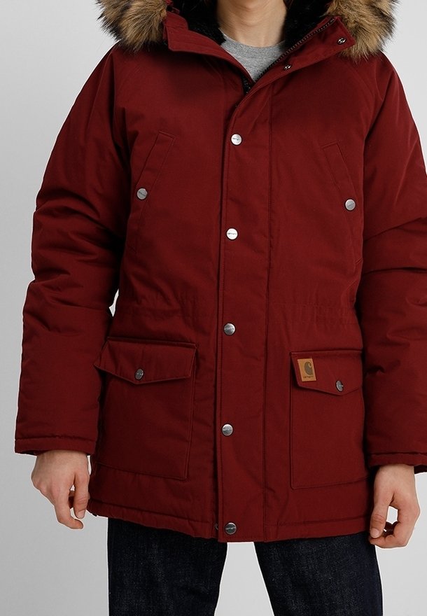 Rode geïsoleerde parka met een bontomrand capuchon, drukknoopsluiting, twee voorzakken en een vierkant logo patch op de linker zak.