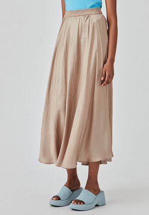 Lett, beige midi-nederdel med elastisk talje, flydende fald og glat tekstur. Kombinationen med lyseblå åbne wedges.