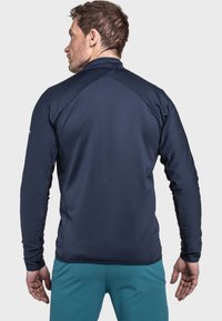 Marineblaues Langarm-Sportjackett aus strukturiertem Stoff mit Stehkragen und Raglanärmeln. Schlichtes Design, Rückansicht.