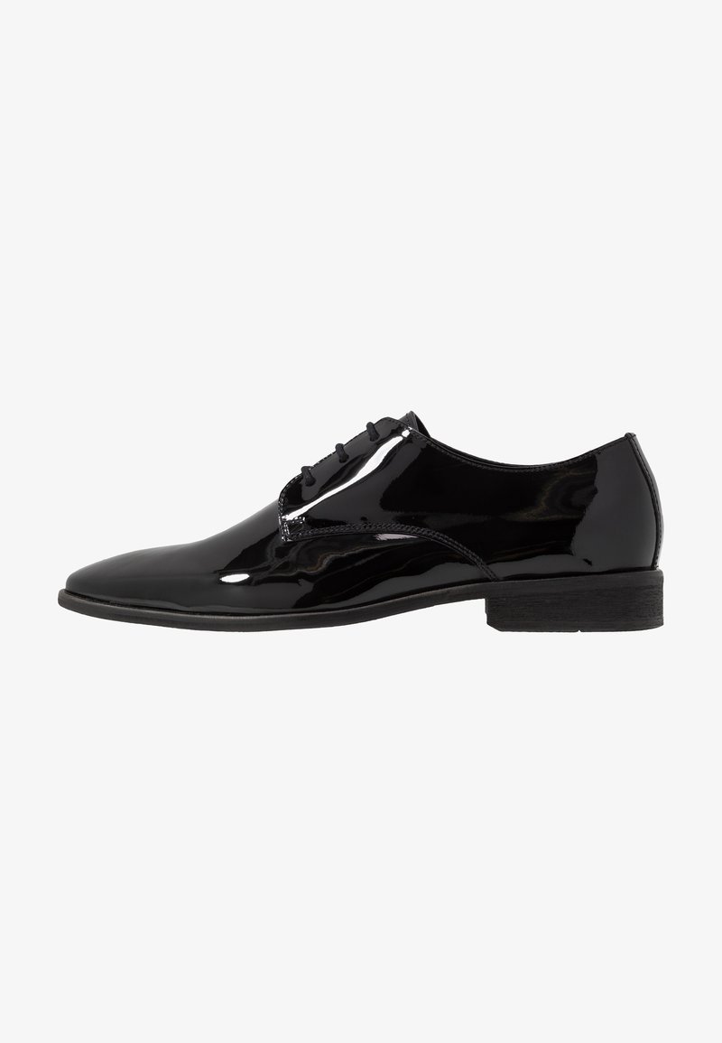 Chaussure de ville pour homme en cuir verni noir, à lacets, avec un petit talon et une finition lisse et brillante, présentée en profil latéral sur fond blanc.