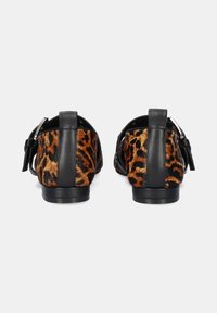 Zapatos de cuero con un diseño de estampado de leopardo, con parte trasera negra y cierre de hebilla. Textura suave, tacón bajo.