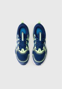 Des chaussures de sport bleues et vert néon avec une tige en mesh, des semelles rembourrées et un design texturé. Elles comprennent une fermeture à lacets et une poignée.