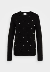 Svart stickad tröja med rundad hals och spridda vita pärlliknande dekorationer. Långa ärmar med ribbad mudd och nederkant.
