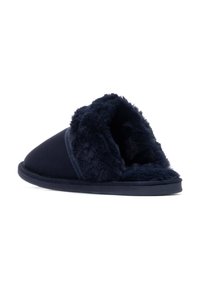 Zapatilla de color azul marino con un puño esponjoso y texturizado y un cuerpo liso. Presenta una punta redondeada y suela plana, diseñada para la comodidad y el calor.