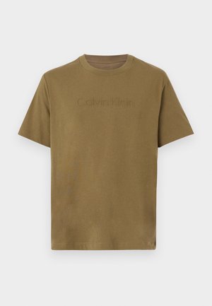 Olivzaļš īsleņķa kokvilnas T-krekls ar reljefēto "Calvin Klein" logo uz krūtīm, apaļu kakla izgriezumu un brīvu piegriezumu.