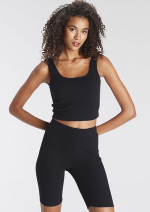 Schwarzes, geripptes Crop-Top und passende Radlerhosen. Hat einen quadratischen Ausschnitt und einen taillierten Schnitt, mit glatter Textur und elastischem Stoff.