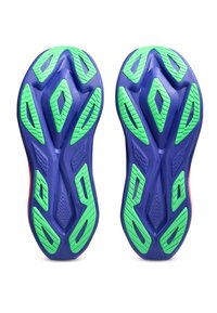 Ζεύγος μπλε και πράσινων λαστιχένιων σολών παπουτσιών με γεωμετρικά σχέδια πέλματος, εμφανιζόμενες από κάτω σε λευκό φόντο.