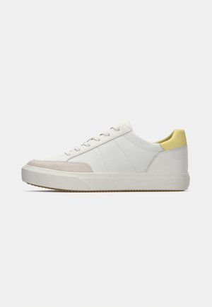 White sneaker with a smooth leather upper, gray suede toe cap, and yellow heel accent. Features round laces and textured rubber sole.