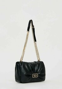 Borsa a tracolla in pelle nera con design trapuntato, dettagli in oro e tracolla a catena. Presenta una chiusura rettangolare con un logo al centro.