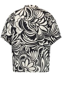 Blouse à manches courtes arborant un motif floral noir et blanc audacieux. Confectionnée en tissu doux avec une coupe décontractée et un col classique.