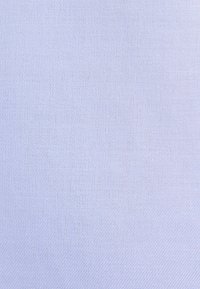 Tissu bleu clair avec un motif subtil en chevrons et de fines lignes diagonales créant texture et profondeur.