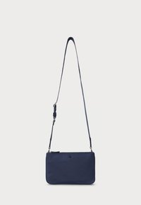 Mörkblå axelremsväska i mjukt tyg, med lång justerbar rem och en diskret logga på framsidan. Enkel rektangulär form.