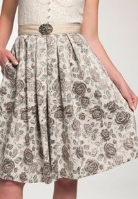 Ein Rock mit floralem Muster in Grau und Beige, mit einem plissierten Design, einem dekorativen Gürtel mit einem Steinakzent und seitlichen Taschen.