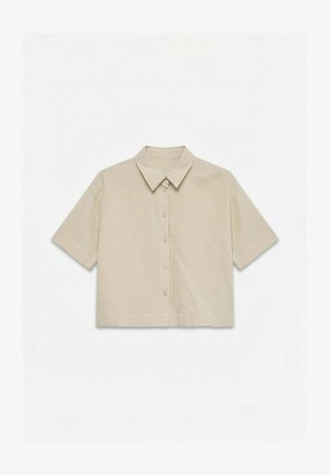 Chemise beige à manches courtes avec boutons et col classique, confectionnée dans un tissu texturé et léger.