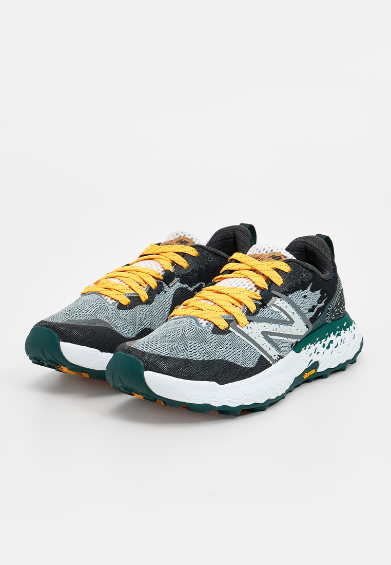Laufschuhe mit einem strukturierten grauen Obermaterial, gelben Schnürsenkeln und türkisfarbenen Akzenten. Sie verfügen über eine gepolsterte weiße Sohle mit einer gemusterten Laufsohle.