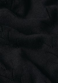 Schwarzer Strickstoff mit einer weichen Textur, der ein dezentes Muster und leicht erhabene Stiche aufweist. Das Material wirkt leicht und flexibel.