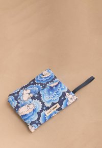 Pochette in tessuto con motivi floreali blu e personaggi Moomin su uno sfondo blu navy. Include una tracolla blu navy e un'etichetta.