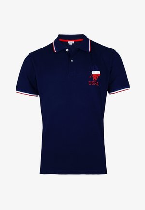 Tengerészkék pamut poloing, piros és fehér csíkkal díszített galléréllel. Hímzett USPA logó a bal mellrészen. Rövid ujjú.