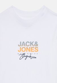 Weißes T-Shirt mit "JACK & JONES" in Grau und Orange gedruckt, gefolgt von "WORLDWIDE" und einer schwarzen kursiven Unterschrift darunter.