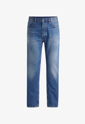 Heledad sinine teksapüksid sirge lõikega, millel on pleekinud laigud, traditsiooniline viie taskuga disain, nööbivarr, ja vöö loopimise kohad.