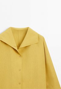 Yellow long-sleeve shirt with wide collar and three visible buttons on a plain white background.