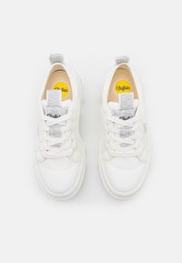 Białe sneakersy z gładkiej skórzanej cholewki, okrągłym noskiem i płaską podeszwą. Posiadają szare sznurowadła oraz tekstylny język z logo. Widoczna żółta wkładka.