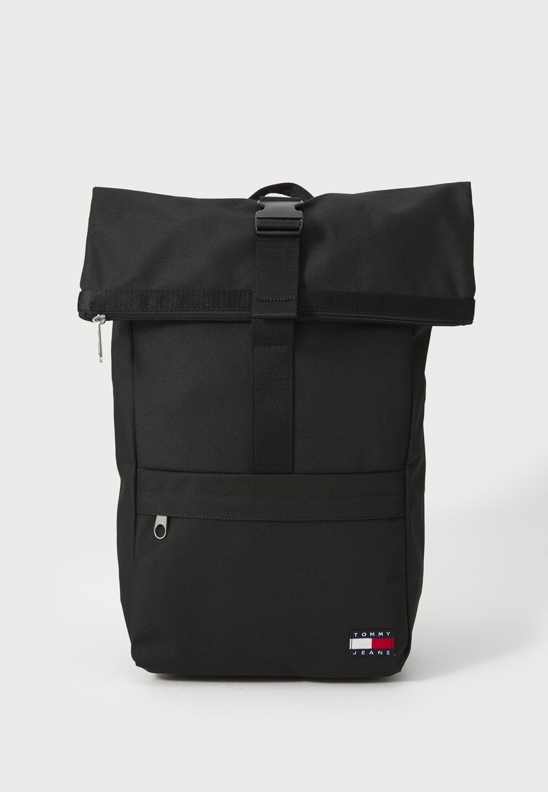 Rucsac negru cu închidere tip ruladă, fabricat dintr-un material durabil, având o buzunar frontal cu fermoar, curea ajustabilă și un ecuson cu logo în partea de jos.