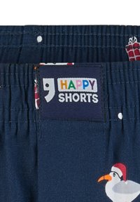 Marineblauwe shorts met een elastische tailleband, voorzien van een bedrukt ontwerp van sneeuwpoppen en cadeaus. Het label zegt "VROLIJKE SHORTS" in kleurrijke letters.